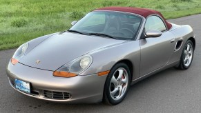 A tan-silver 2002 Porsche Boxster S on a road