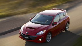 A red 2012 Mazdaspeed 3 photographed from a high angle while driving shows that its the perfect affordable used car that is also a killer sleeper car.