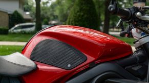 The right side of a red 2012 Triumph Street Triple R with black tank grips installed