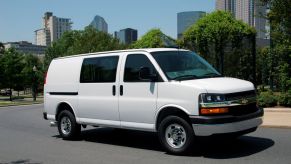 A white 2016 Chevrolet Express 2500 Cargo Van on a city street