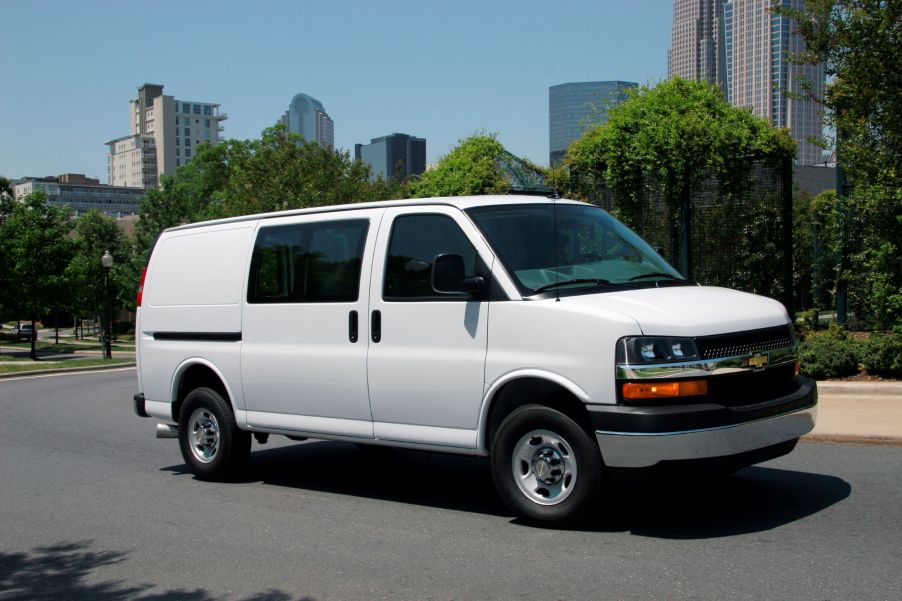 A white 2016 Chevrolet Express 2500 Cargo Van on a city street