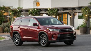 A dark-red metallic 2017 Toyota Highlander SE parked outside a restaurant