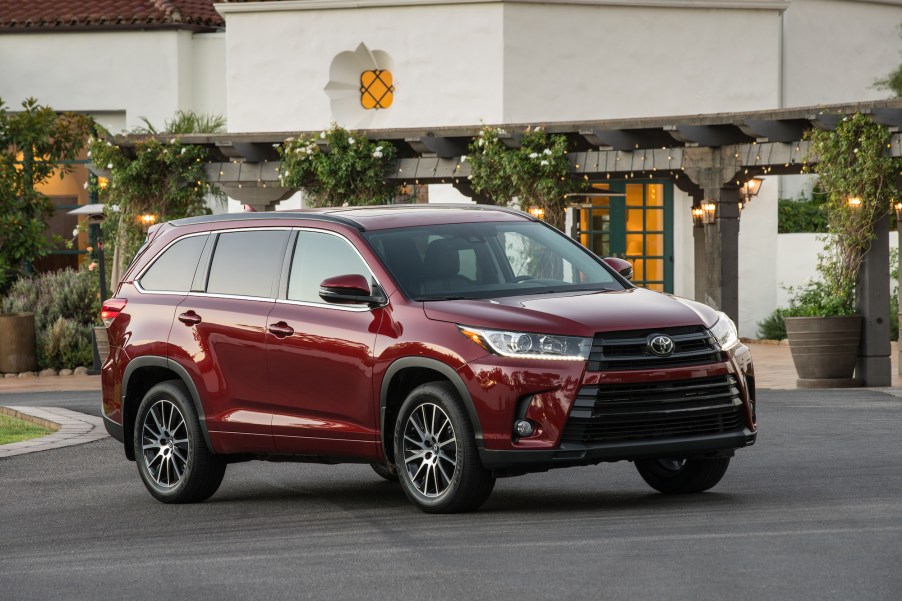 A dark-red metallic 2017 Toyota Highlander SE parked outside a restaurant