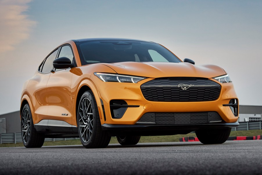 An orange 2021 Ford Mustang Mach-E GT parked on a racecourse