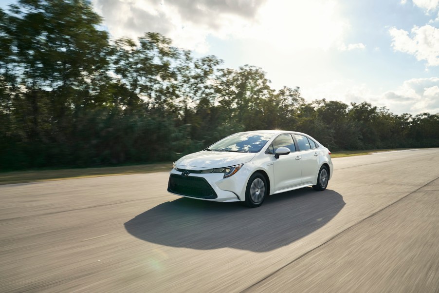 A white 2021 Toyota Corolla Hybrid driving, the 2021 Toyota Corolla Hybrid is a new sedan and is one of the most fuel-efficient new cars