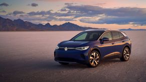 The 2021 Volkswagen ID.4 Pro S EV SUV model parked on a barren plain near mountains and a setting sun