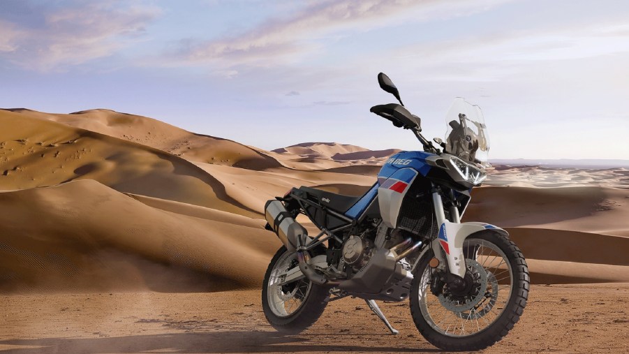 A white-blue-and-red 2022 Aprilia Tuareg 660 in the desert