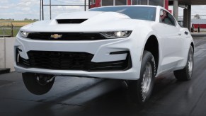 A white 2022 Chevrolet COPO Camaro wheelies down a dragstrip