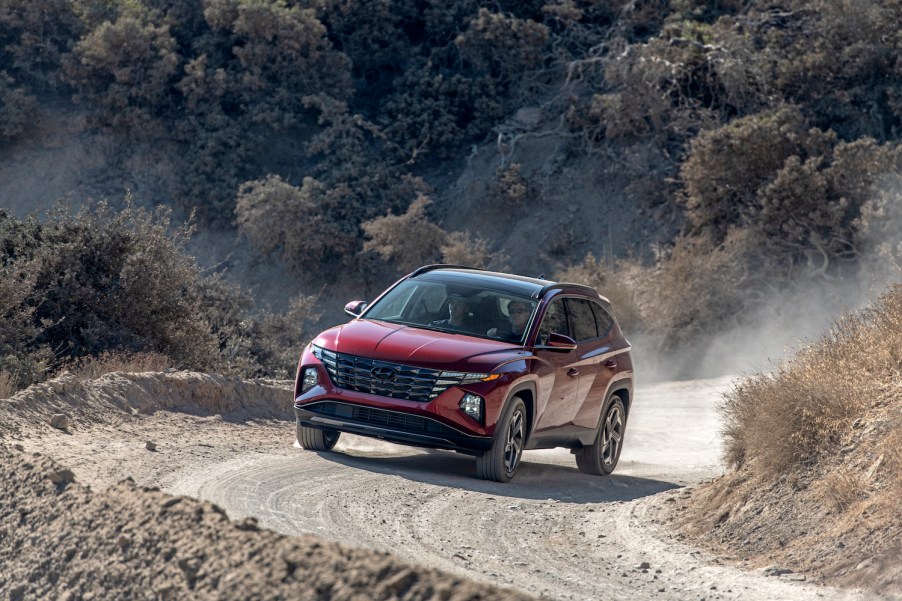 A red 2022 Hyundai Tucson driving up a dirt hill, the 2022 Hyundai Tucson is the best AWD SUV of 2021