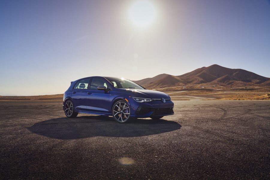 Passenger's side front view of blue 2022 Volkswagen Golf R with mountains in the background