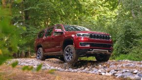 A red 2022 Wagoneer with Advanced All-Terrain Group off-roading through the forest