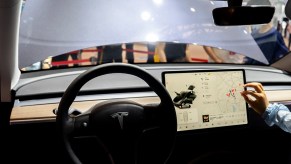 The steering wheel and screen of the inside of a Tesla.