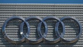 Chrome Audi logo on a mesh grille looking background.