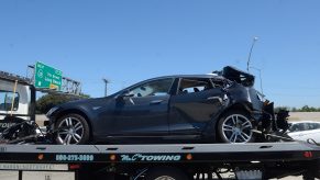 A crashed Tesla sits on a flatbed