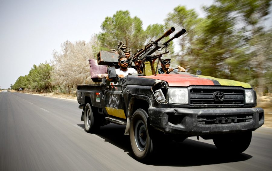 NTC fighters toting guns in a modified Toyota Land Cruiser in Libya