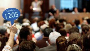 An auction bidder raises their card at a Sotheby's auction