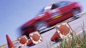 A BMW passes in a red blur on an autocross course