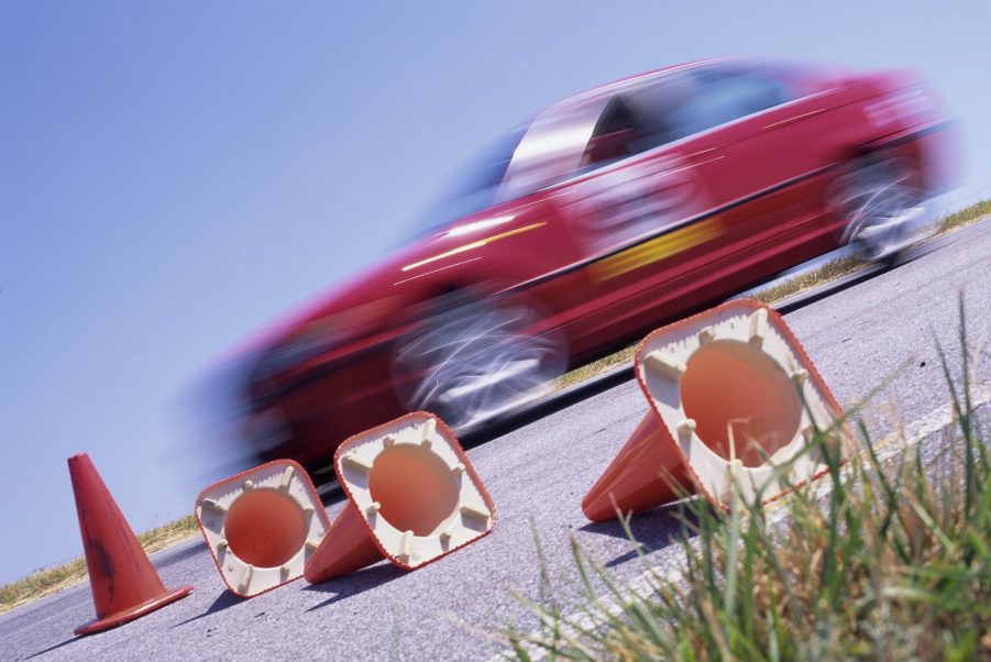 A BMW passes in a red blur on an autocross course