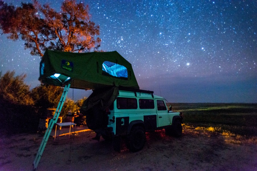 A rooftop tent on a land rover in Botswana. Find out the best rooftop tents for overland camping.