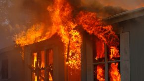 Flames pour from the window of a burning building