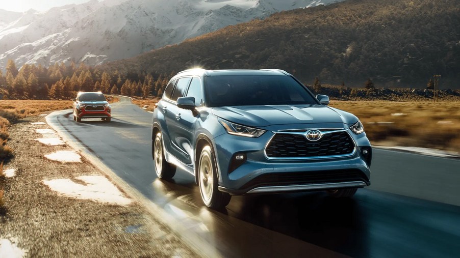 A dark blue 2021 Toyota Highlander on a quiet road.