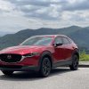 A red 2021 Mazda CX-30 turbo parked in front of a mountain view