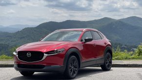 A red 2021 Mazda CX-30 turbo parked in front of a mountain view