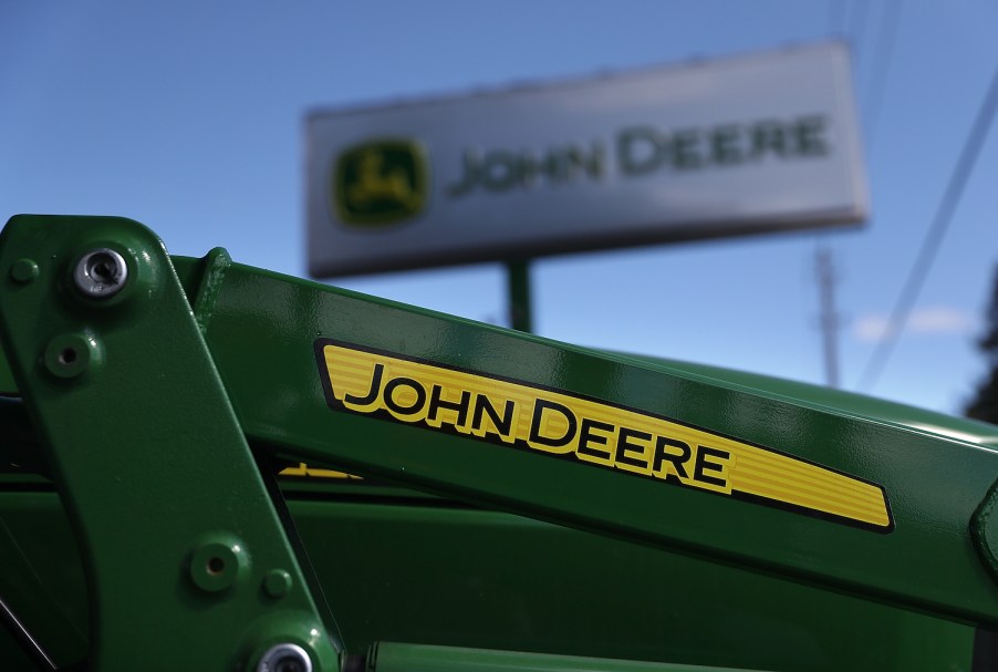 The John Deere logo on a tractor, John Deere makes some of the best zero-turn lawn mowers according to Consumer Reports