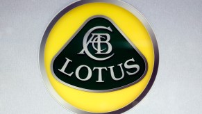 A yellow, black, and silver Lotus logo on display at the 2018 Paris Motor Show