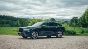 A forest green 2021 Bentley Bentayga Hybrid in the forest