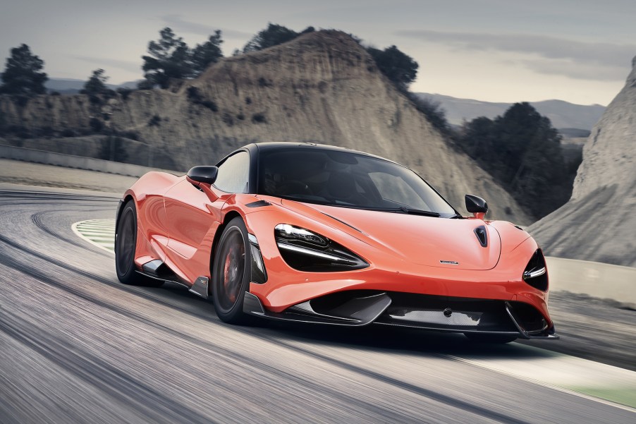 2021 McLaren 765LT supercar in orange driving on the road towards the camera.