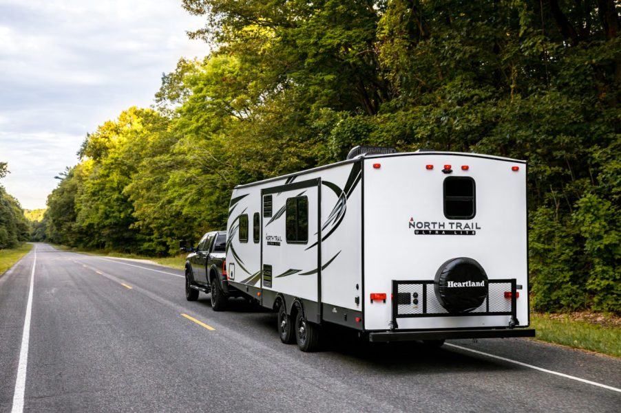 a North Trail travel trailer being pulled on a road in the forest