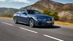 A blue 2021 BMW M440i coupe on a mountain road