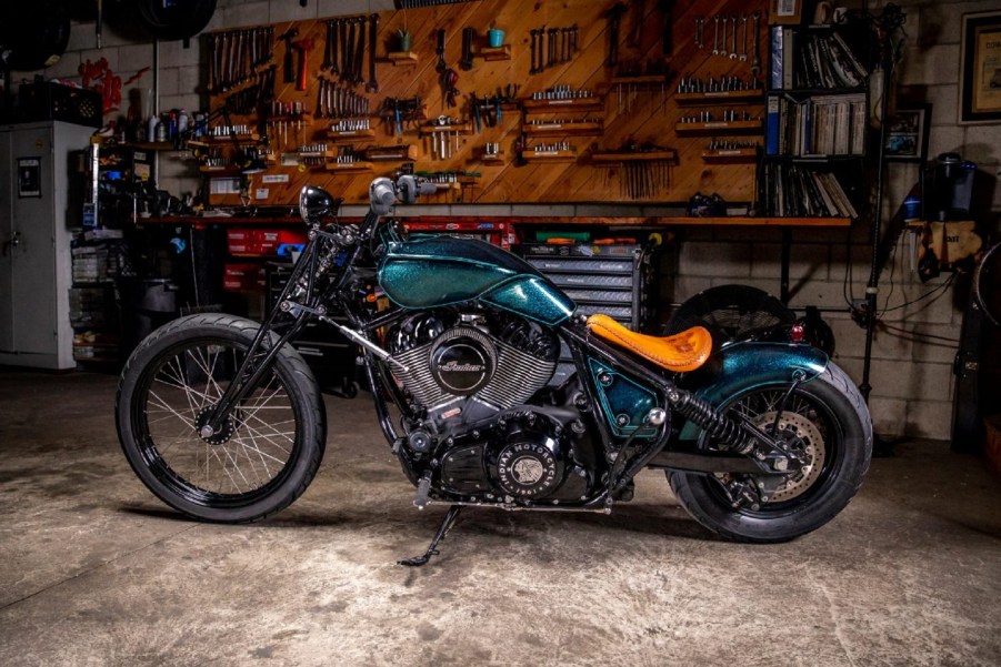 The side view of Paul Cox's and Keino Sasaki's metallic-green custom 2022 Indian Chief in a garage