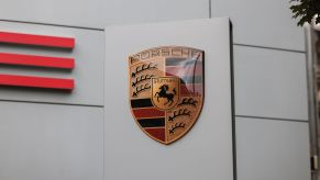 A Porsche sign in front of a building with the logo.