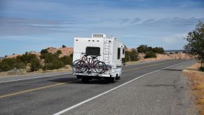 A moving RV with bikes on the back driving in New Mexico