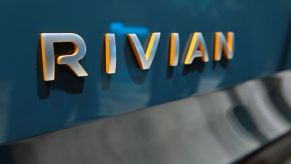 Rivian spelled out in metal letters on the back of a dark teal piece of metal.