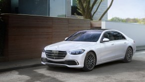 A white 2021 Mercedes S-Class parked outside of a house.