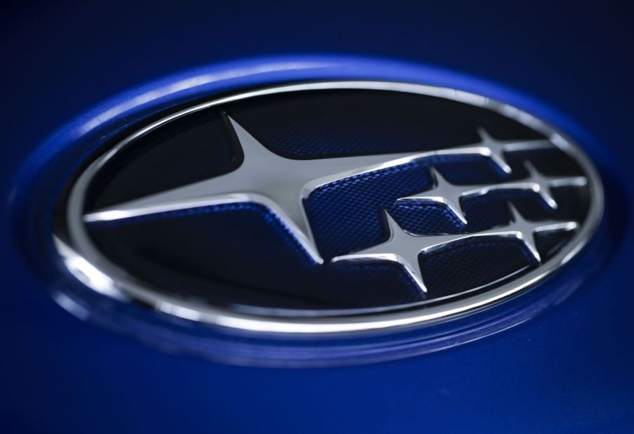 A dark blue Subaru logo with silver accents against a lighter blue background.