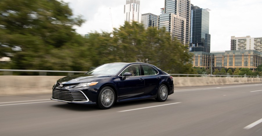 A black 2021 Toyota Camry driving, the Camry is the best sedan of 2021