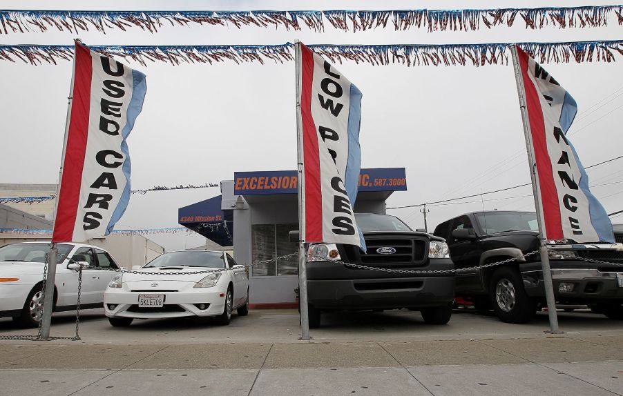 A used cars lot with flags and used cars.