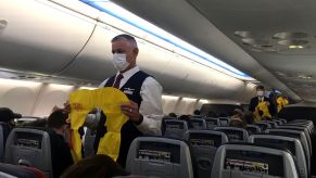 Flight attendants checking safety precautions in an airplane cabin before takeoff