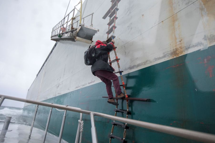 A harbor pilot climbing a boat ladder in Boston Harbor of Boston, Massachusetts