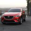 A red 2021 Mazda CX-3 parked with a city in the background.