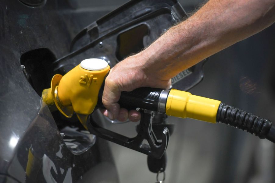 A driver filling up their vehicle's gas tank at a gas station