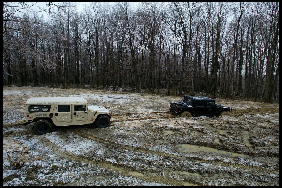 A beige H1 hummer winches a black H1 tug-of-war