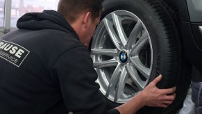 A tire shop mechanic rotate tires