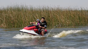 A man and a child ride a WaveRunner on Lake Parker in Lakeland, Florida