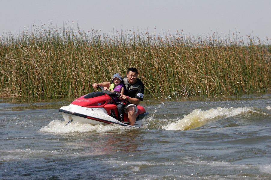 A man and a child ride a WaveRunner on Lake Parker in Lakeland, Florida