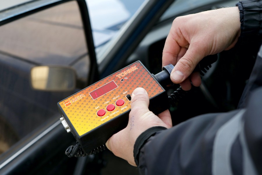 Police officer checks the transparency of car windows